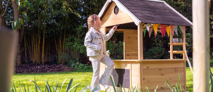 Maedchen spielt mit Holzspielhaus 1700x740